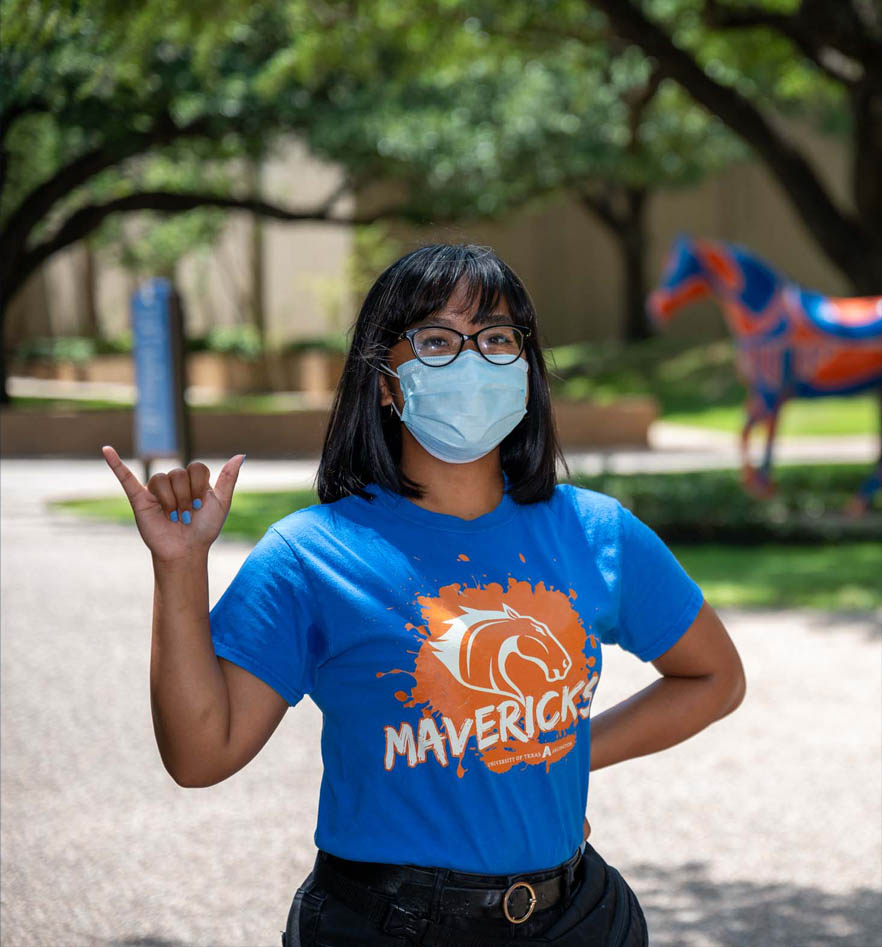Kyra giving a mavs up in front of UTA horse