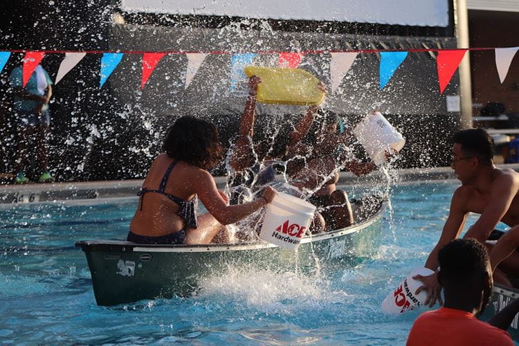 Students spashing each other on a kayak at the UTA outdoor pools