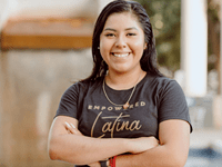 Picture of Yvonne Dominguez, Assistant Director of Fraternity & Sorority Life, with crossed arms in a black t-shirt that says "Empowered Latina". 