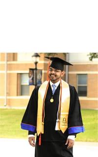 Fraternity member in graduation cap and robe outside