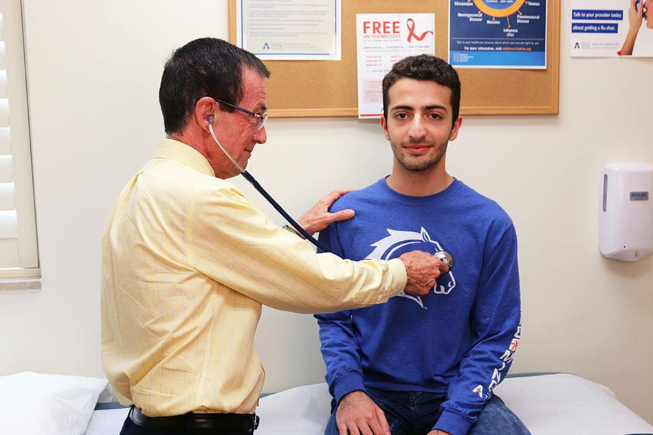 A patient being examined by a doctor using a stethoscope