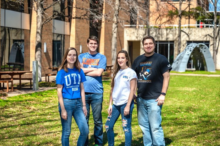 Students standing outside smiling.