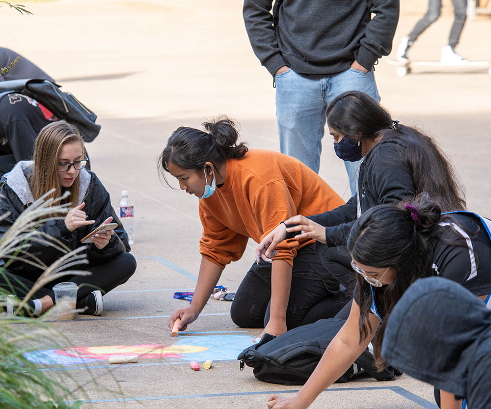 students chalking the sidewalk