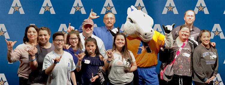 A large family posing with Blaze the mascot.