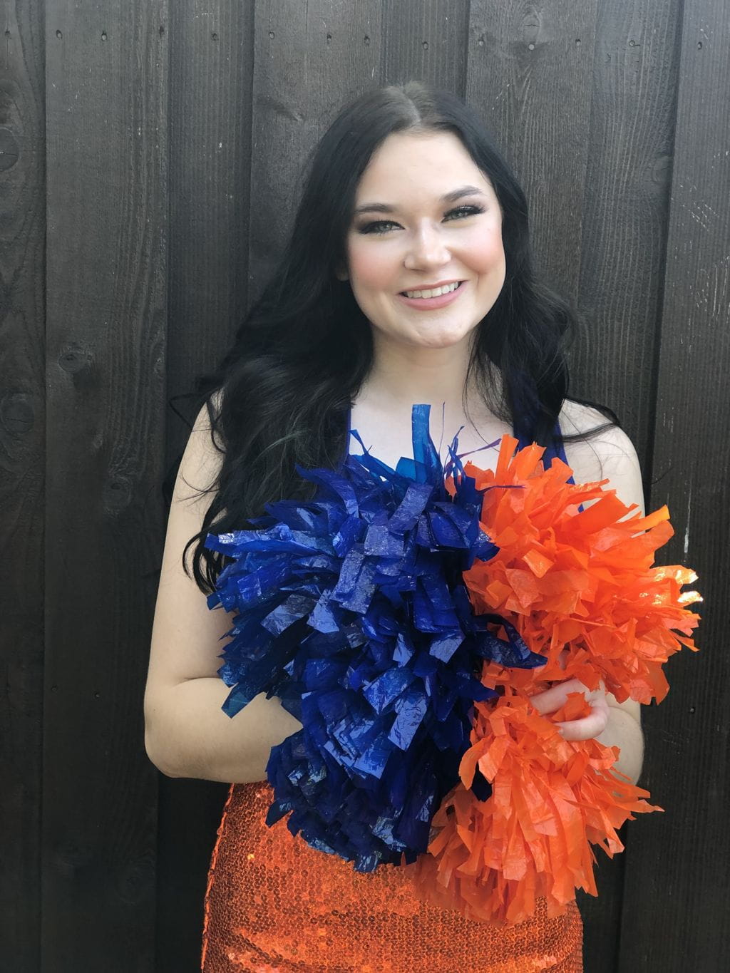 Dancer Kyra Gaskill smiling with her pompoms