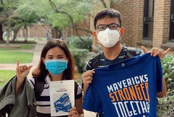 Students with masks on holding a t-shirt