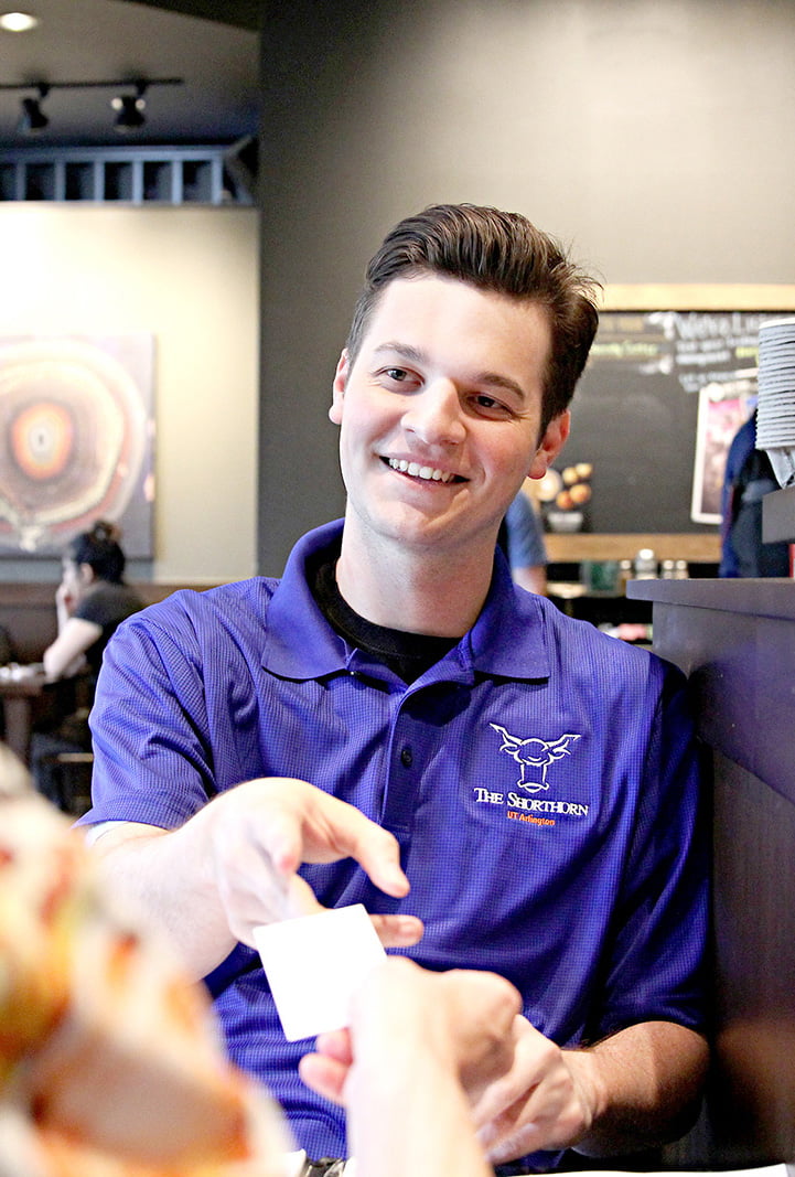 Alum Austin Hutchinson in a restaurant being given a card