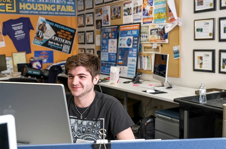 The Shorthorn staff member at a computer doing work
