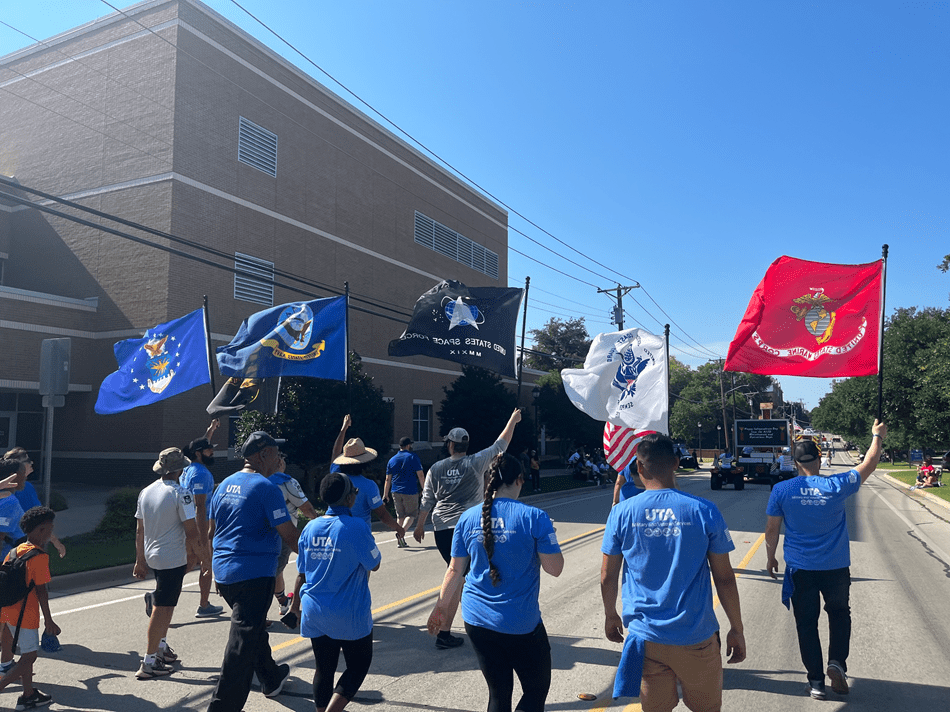 Student veterans carrying service branch flags in a parade