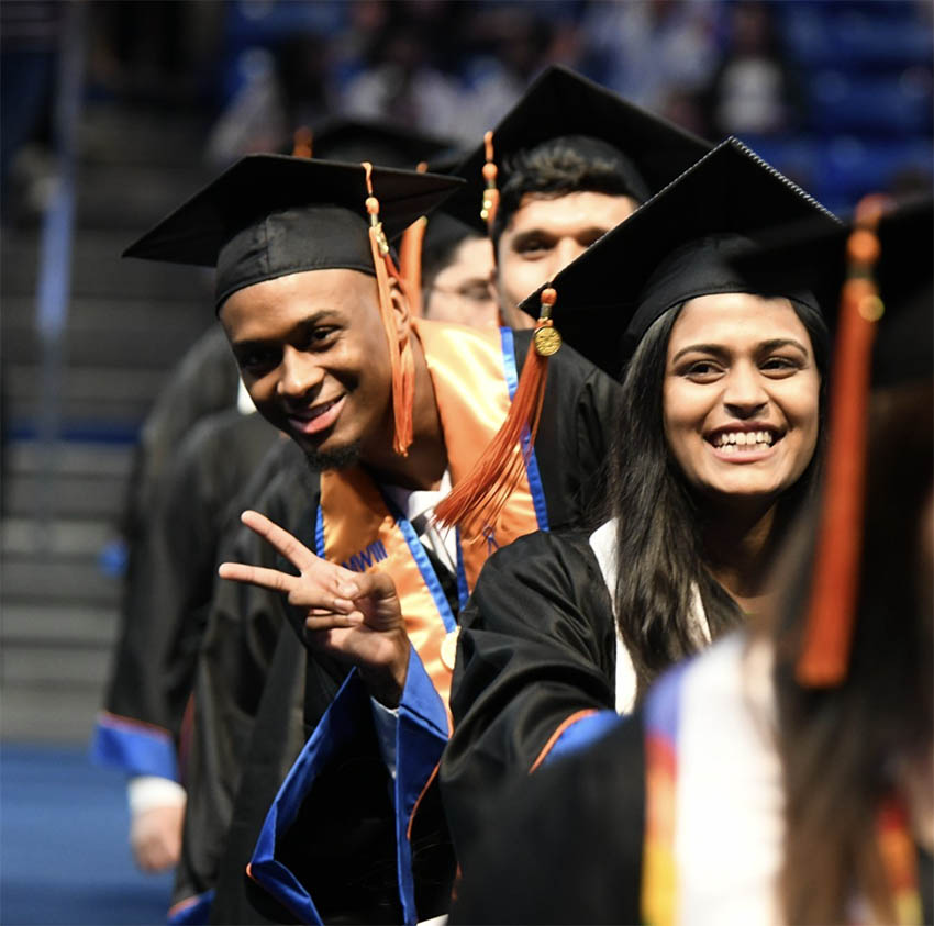 graduates smiling during commencement ceremony at college park