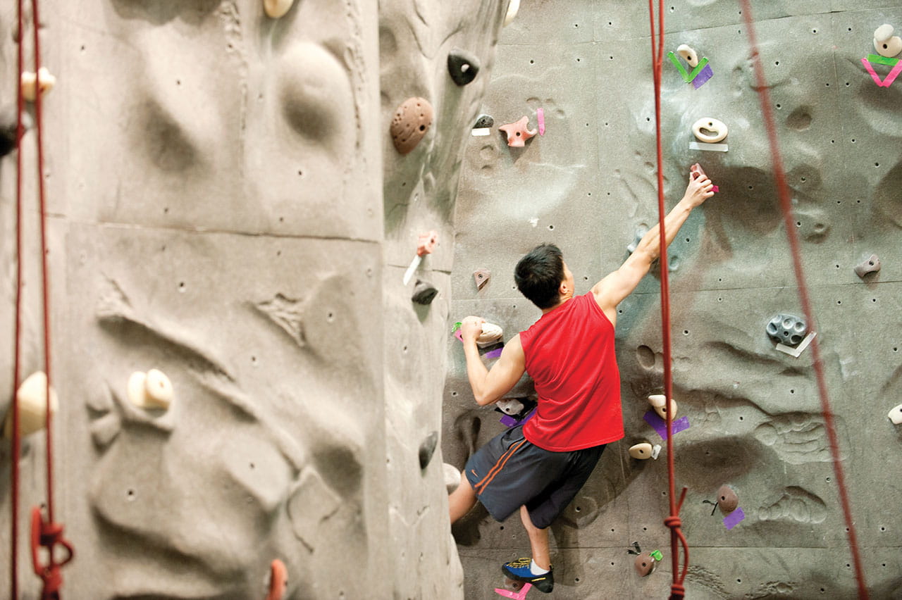 student rock climbing at the MAC