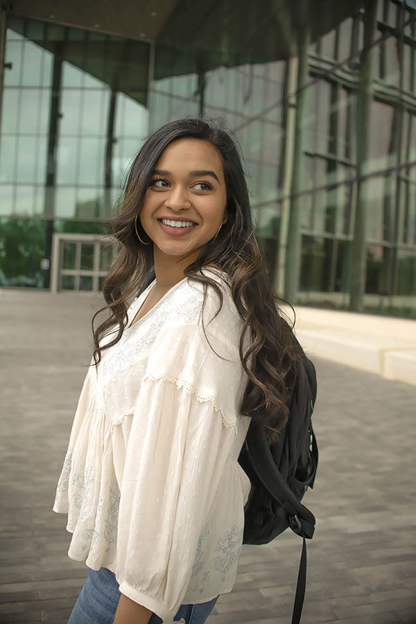 Student standing in front of the UTA building